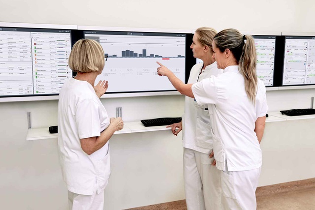 Nurses discuss bed capacity based on patient flow forecasts on screens from the INSIGHT patient flow management solution