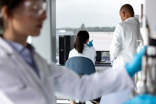 Scientists working in lab watching monitor